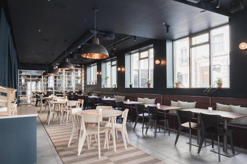 a restaurant with tables and chairs and windows at Heimen Hotel in Bergen