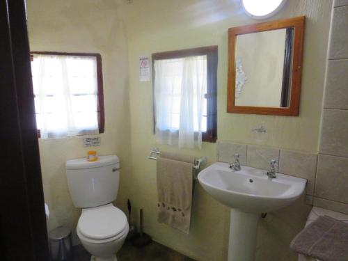 a bathroom with a toilet and a sink at Kruger Maroela Lodge in Marloth Park