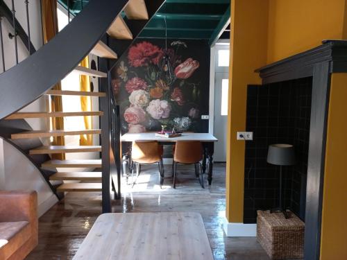 a dining room with a table and a painting on the wall at vakantiewoning - Achterom in Ommen