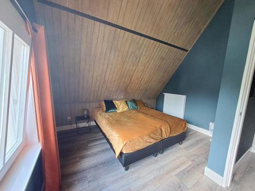 een slaapkamer met een bed en een houten plafond bij vakantiewoning - Achterom in Ommen