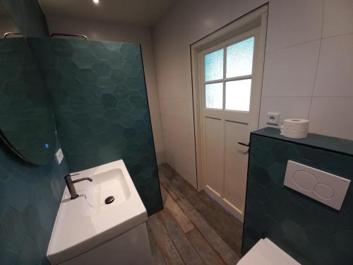 een badkamer met een toilet, een wastafel en een raam bij vakantiewoning - Achterom in Ommen