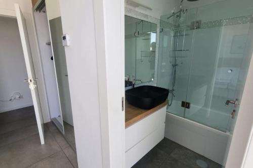 uma casa de banho com um lavatório e uma cabina de duche em vidro. em Penthouse Sea View in Ben Yehuda by HolyGuest em Tel Aviv