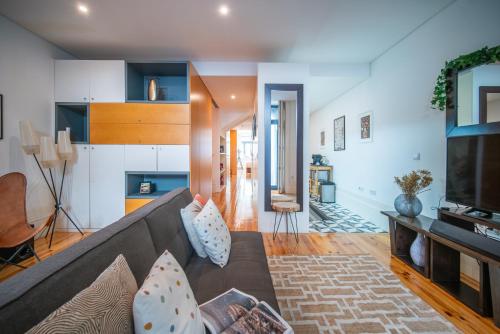 - un salon avec un canapé et une télévision dans l'établissement JOIVY Modern flat with patio in central Porto, à Porto