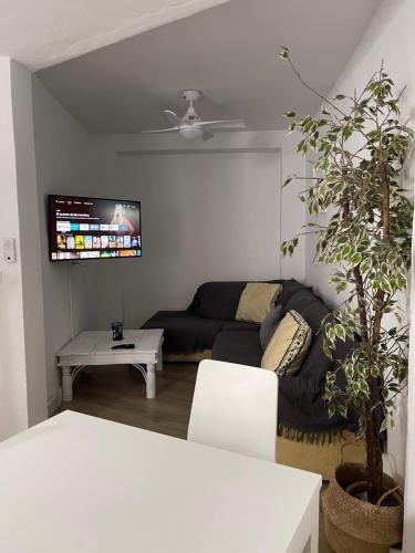 - un salon avec un canapé et une télévision dans l'établissement La Churrera alojamiento rural, à Yunquera