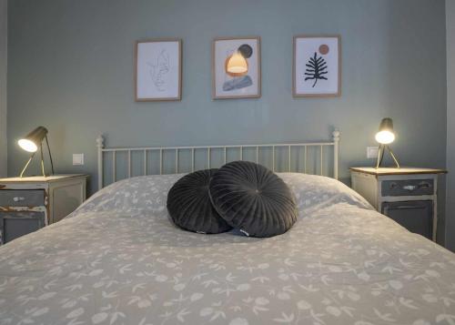 ein Kissen auf einem Bett mit drei Bildern an der Wand in der Unterkunft Apartamento Gran Canaria La Mariposa in Vega de San Mateo