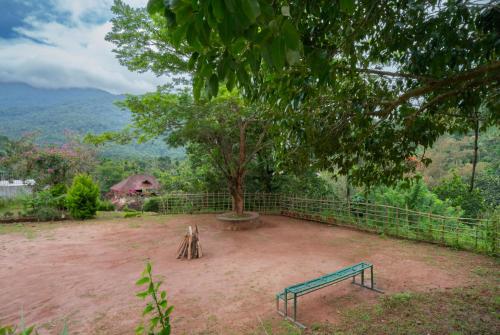 a park with a bench and a tree at Misty Heights by The Sanihara in Vayittiri