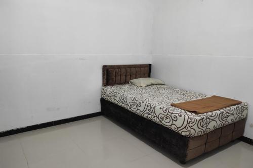 a small bed in a room with a white wall at OYO 93060 Wisma Astukara Syariah in Enrekang