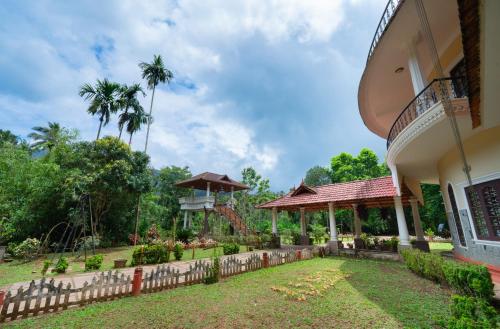 a house with a fence in front of a yard at Misty Heights by The Sanihara in Vayittiri