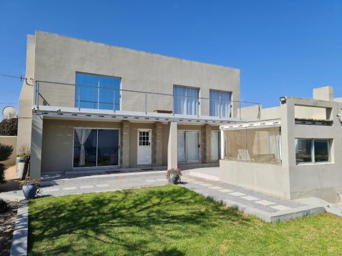 a large white house with a lawn in front of it at Peaceful Place in Port Nolloth
