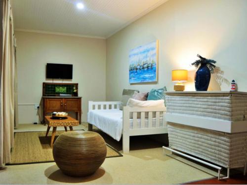 a room with a bedroom with a bed and a tv at Peaceful Place in Port Nolloth