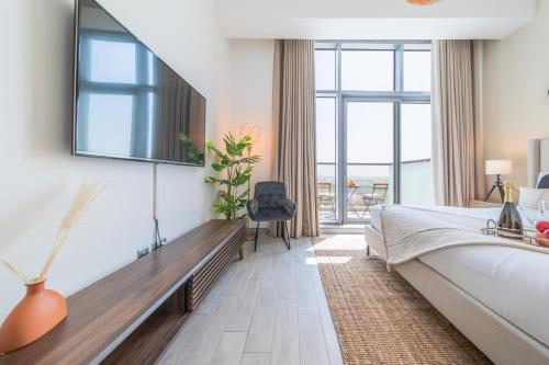 - une chambre avec un lit et une télévision murale dans l'établissement EDEN'S Homes & Villas - Millennium Atria Residences, à Dubaï