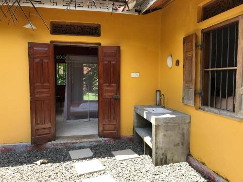 a bathroom with a sink in a yellow wall at Dragon-Fly Home Hikka in Dodanduwa