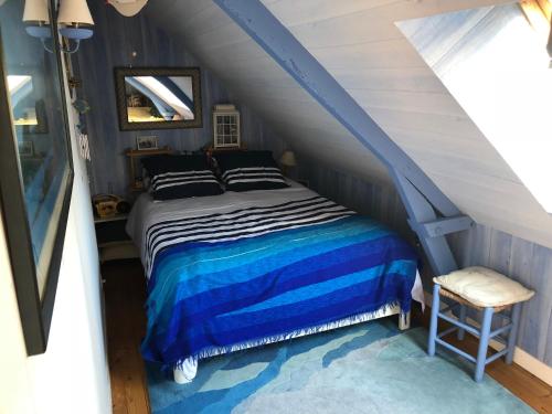 une chambre avec un lit avec une couette bleue et blanche dans l'établissement Maison Saint Gildas de Rhuys, à Saint-Gildas-de-Rhuys
