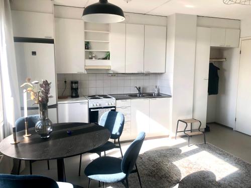 a kitchen with a black table and chairs and a table at Top floor one bedroom apartment with balcony in Helsinki