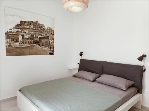 łóżko w białym pokoju z obrazem na ścianie w obiekcie Casa Giuseppe Castelsardo w mieście Castelsardo