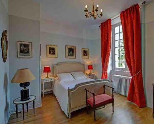 um quarto com uma cama, uma cadeira e uma janela em Grand gîte pour 28 personnes dans un château en Normandie em Beuzevillette