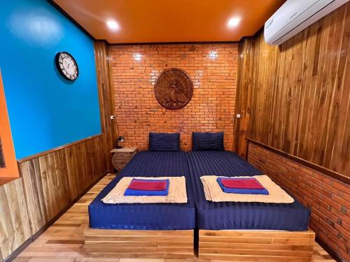 1 dormitorio con 2 camas y pared de ladrillo en ชานไม้ รีสอร์ท 