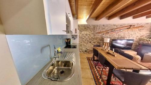 una cocina con fregadero en el medio de una habitación en Casa Cubero - tucasaenlospirineos en Sallent de Gállego