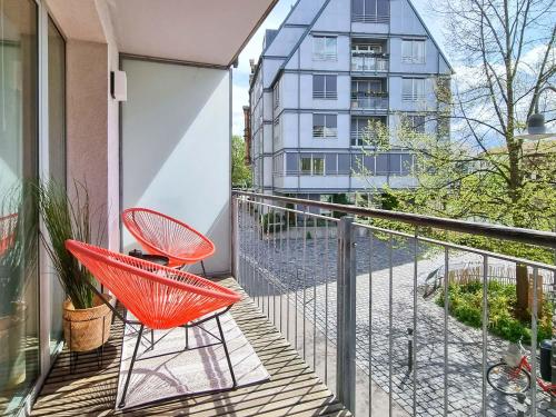 a red chair on a balcony with a building at LINDE3 - 10 Minuten in die Altstadt mit Balkon und Pegnitzblick in Nürnberg