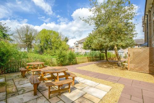 a patio with a picnic table and benches at Two Bedroom Duplex Apartment The Priory - St Ives in St Ives