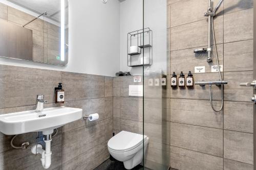 a bathroom with a toilet and a sink and a shower at Stay Apartments Bolholt in Reykjavík