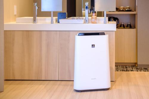 a white refrigerator in a kitchen with a counter at Tosei Hotel Cocone Tsukiji Ginza Premier in Tokyo