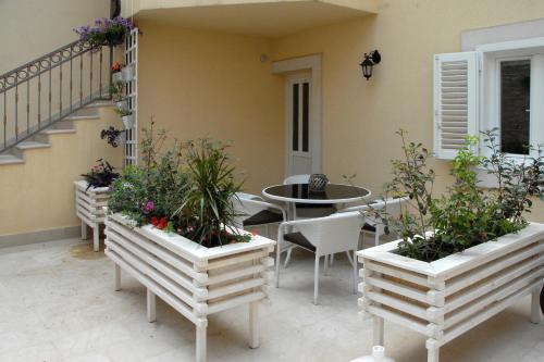 a patio with a table and chairs and some plants at Luxury Apartment Spa "Marina" in Makarska