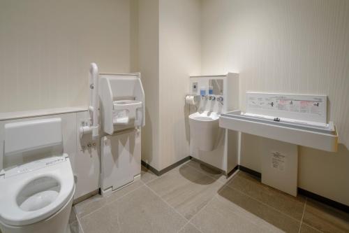 a bathroom with a toilet and a sink and two toilets at Tosei Hotel Cocone Tsukiji Ginza Premier in Tokyo