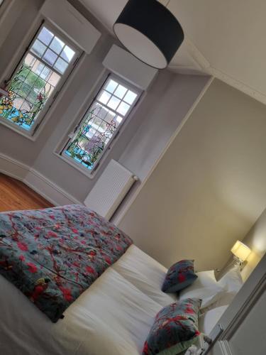 a bedroom with a bed and two windows at L'Ourson in Colmar