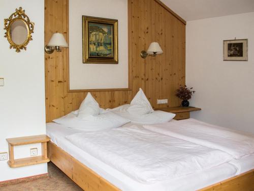 ルーポルディングにあるFerienwohnungen v. Knoerzer-Suckowの木製の壁のベッドルーム1室(白い大型ベッド1台付)