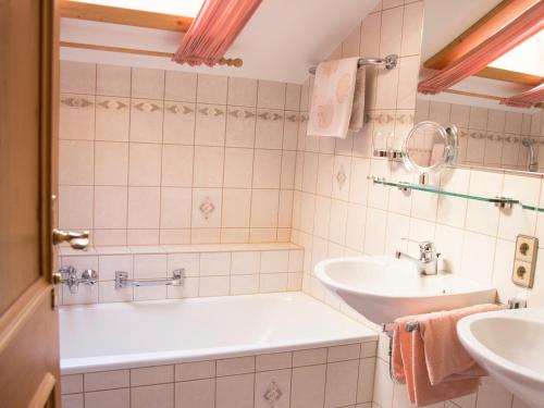 a bathroom with a tub and a sink at Ferienwohnungen v. Knoerzer-Suckow inkl. Chiemgaukarte in Ruhpolding
