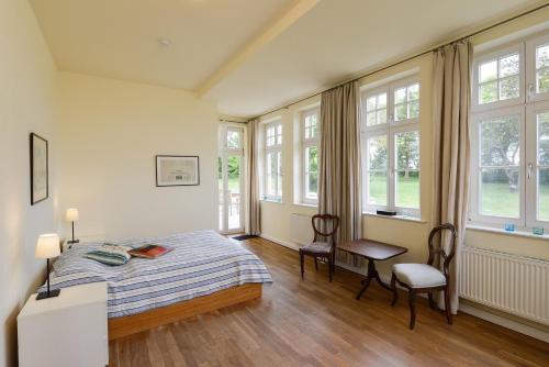 a bedroom with a bed and a table and chairs at Ferienwohnung 3 mit gr Terrasse und Wasserblick in Neuenkirchen