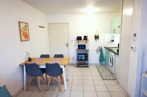 une cuisine avec une table et des chaises dans une pièce dans l'établissement Grand studio lumineux et sa terrasse au calme, à Toulouse