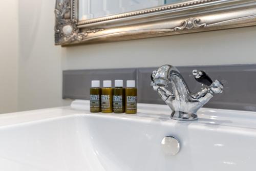 a bathroom sink with a faucet and a mirror at 1BR gem in the heart of Covent Garden with aircon in London