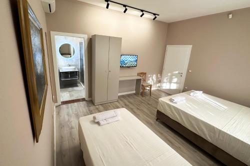 1 dormitorio con 2 camas y escritorio con TV en Nicolaus Hidden Gem Villa en Shkodër