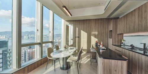 a kitchen with a table and chairs and large windows at The Stellar in Hong Kong