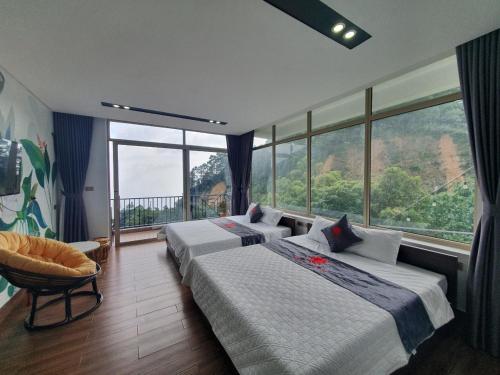 1 dormitorio con 2 camas y ventana grande en Phượng Chi Homestay Venuestay, en Tam Ðảo