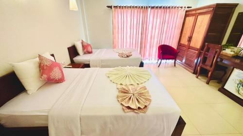 a room with two beds and a table with a umbrella on it at Holy Angkor Hotel in Siem Reap