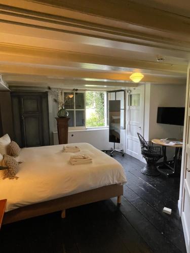 a bedroom with a bed and a desk and a television at Eco Hotel Plantage Rococo in Velsen-Zuid