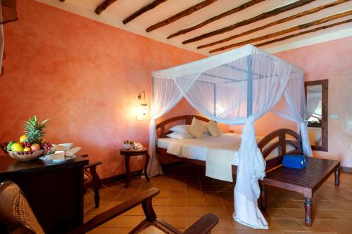 - une chambre avec un lit à baldaquin dans l'établissement Hotel Club Dongwe, à Pingwe