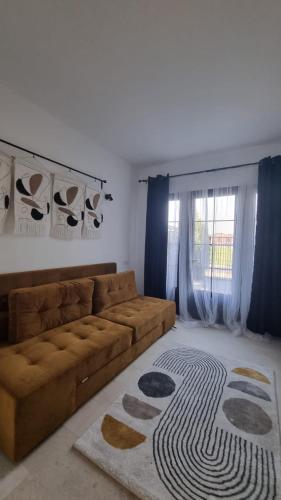 un soggiorno con divano marrone e tappeto di CH Residence a Chişoda