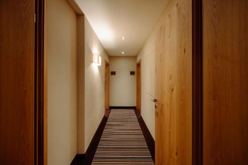 a hallway with wooden walls and a long corridor at Das gemütliche Dorfhotel Kaltenhauser in Hollersbach im Pinzgau