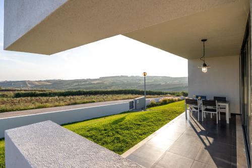 a patio with a table and a view of a field at Carina Villas in Lourinhã