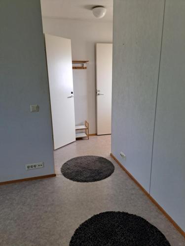 una habitación vacía con dos puertas y alfombras en el suelo en Vuolteentie 38 D 25, en Kauhajoki