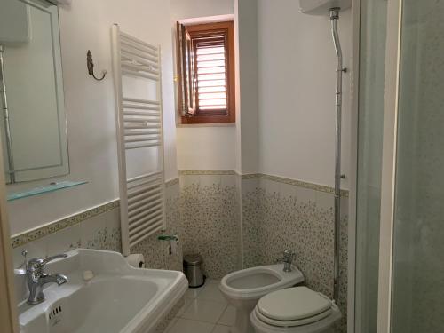 a bathroom with a white toilet and a sink at Kasakarin in Scilla