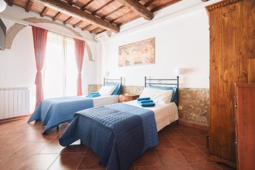 een slaapkamer met 2 bedden met blauwe lakens bij Villa San Giusto - Pool&Relax in Montemassi