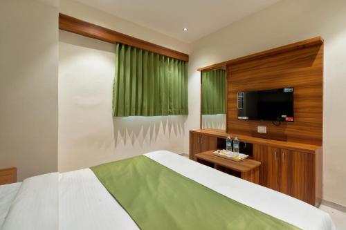 Schlafzimmer mit einem Bett und einem Flachbild-TV in der Unterkunft HOTEL ROYAL 21 in Ahmedabad
