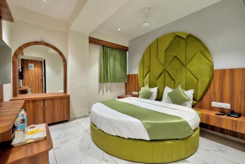 a bedroom with a large bed with a large headboard at HOTEL ROYAL 21 in Ahmedabad