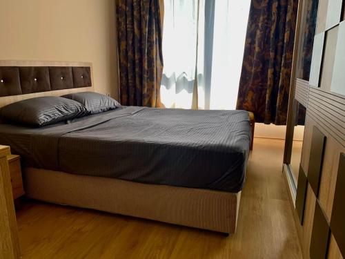 a bed in a bedroom with a large window at Apartment with a lake view in Istanbul koza park borgaz in Esenyurt