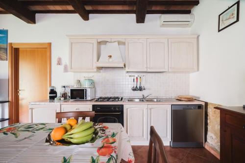 a kitchen with a table with a bowl of fruit on it at Villa San Giusto - Pool&Relax in Montemassi